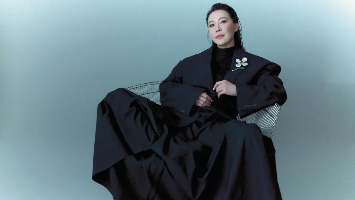 Cindy Chao wearing a Balenciaga blazer, turtleneck, skirt, shoes and CINDY CHAO The Art Jewel White Label Collection Sapphire Floral Brooch