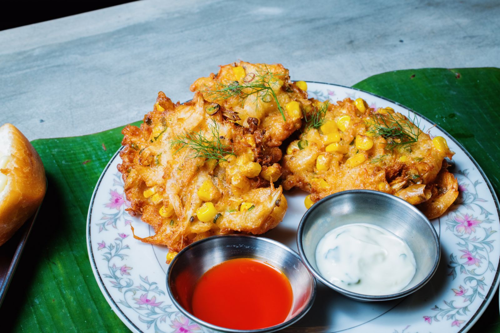 Corn fritters with raita and chilli sauce