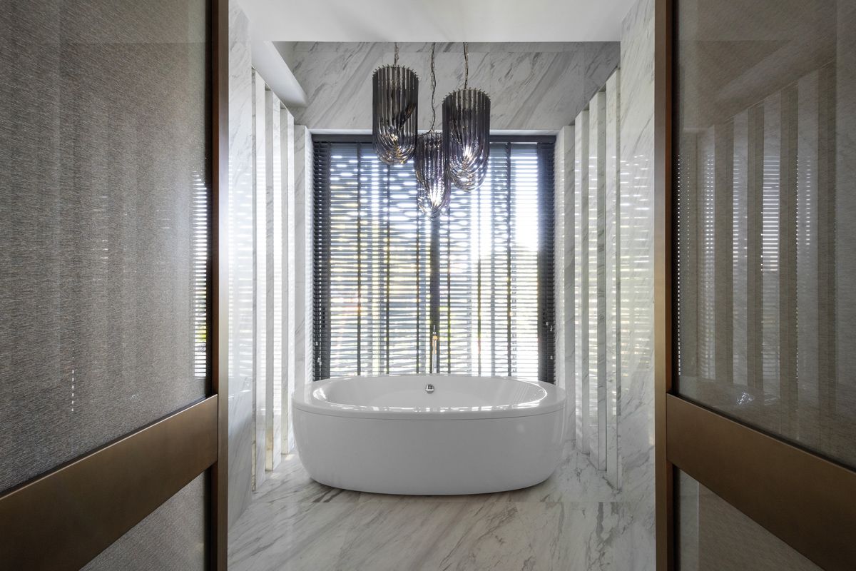 A freestanding bathtub and a trio of chandeliers epitomise luxury in the master bathroom