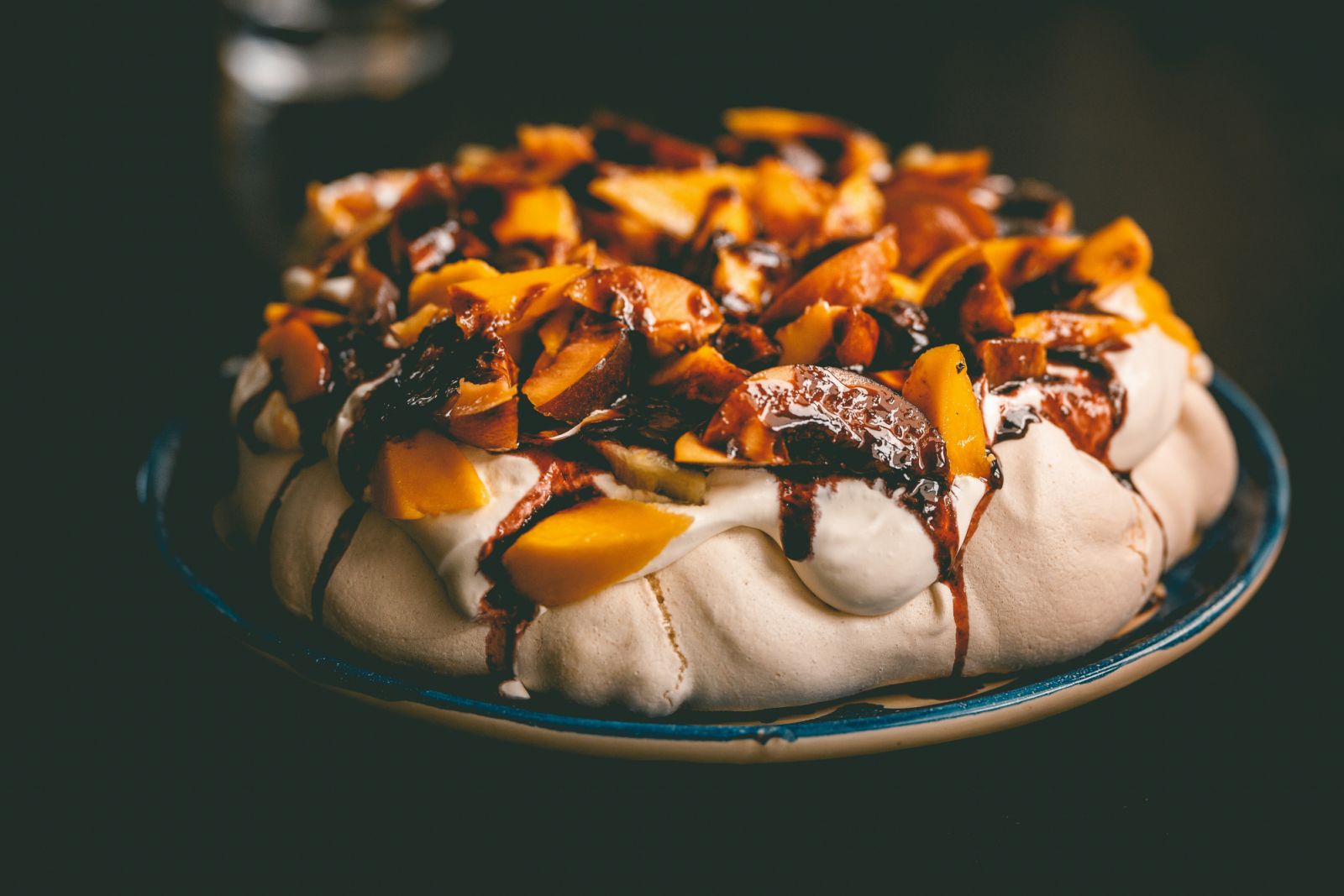 A pavlova topped with stone fruit, a dessert that might be an Australian invention