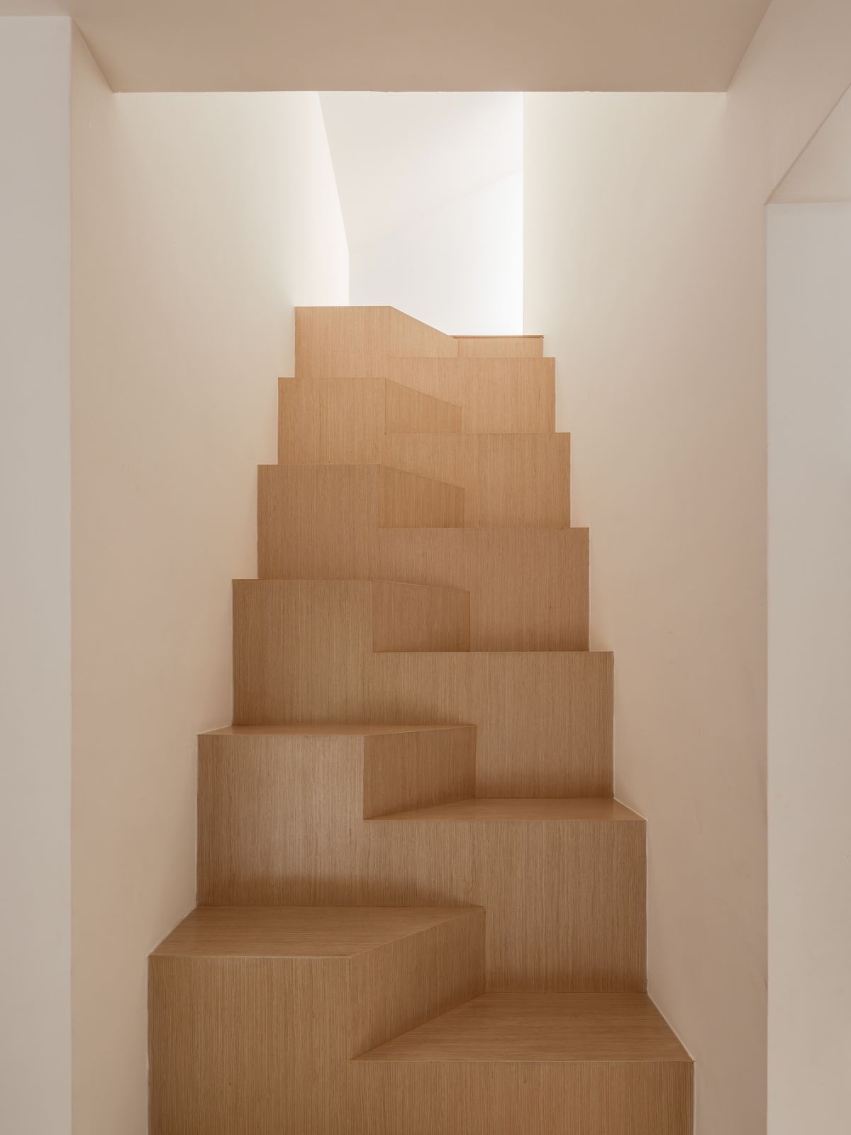 The space-saving alternating-tread staircase to the attic demonstrates creative problem-solving within spatial constraints