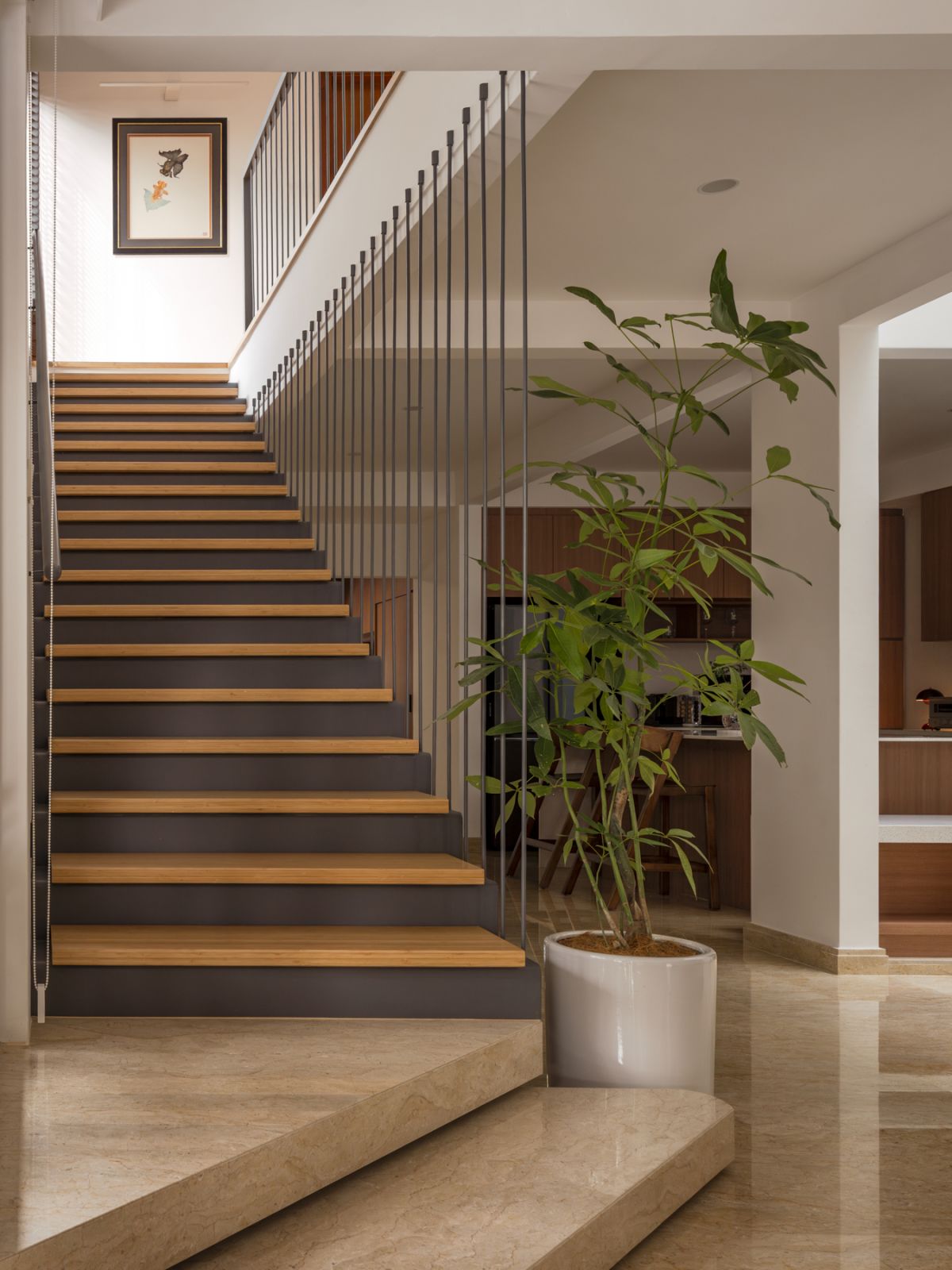 The main staircase combines folded steel plates and warm bamboo treads, with a commissioned goldfish artwork adding a personal touch to the double-height space