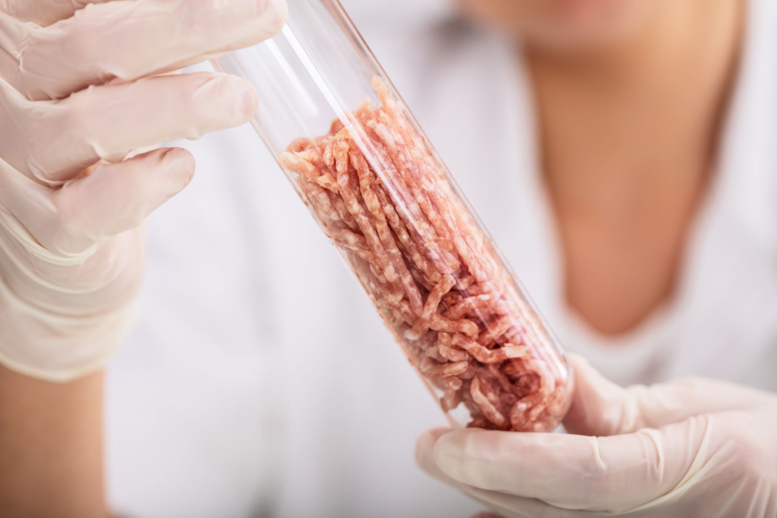 Scientist Hand In Protective Glove Holding Raw Artificial Grown Meat In Laboratory Test Tube