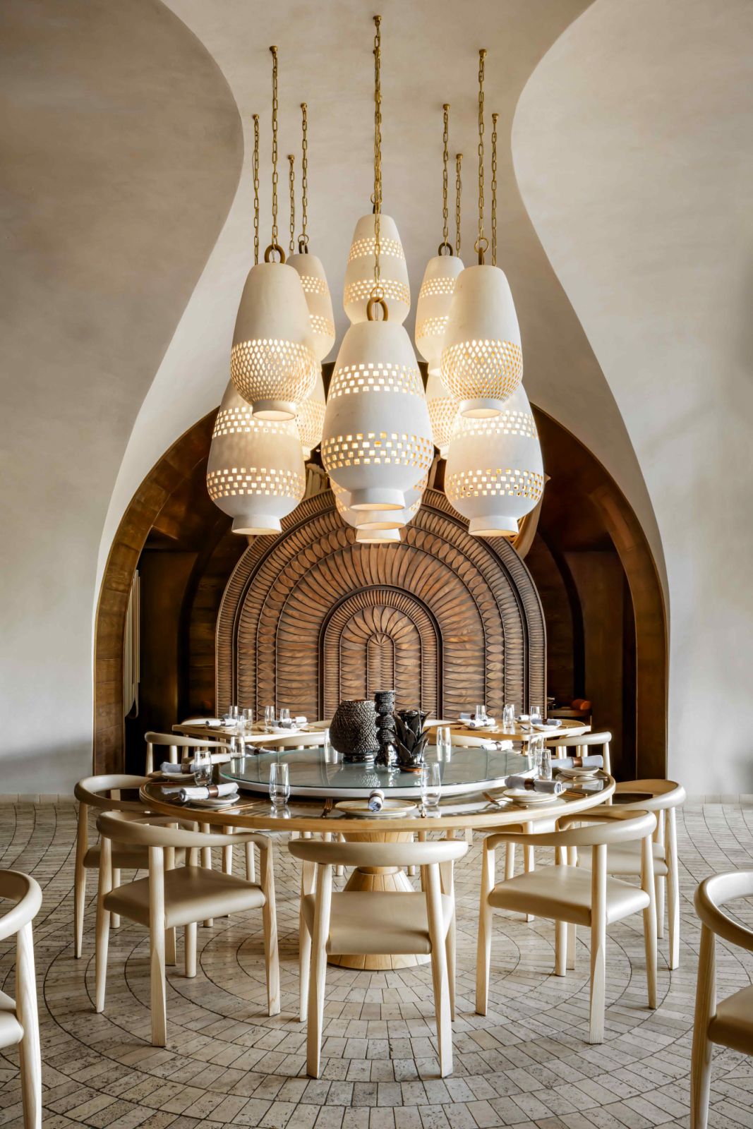 Statement perforated clay pendants cluster in the semi private dining area