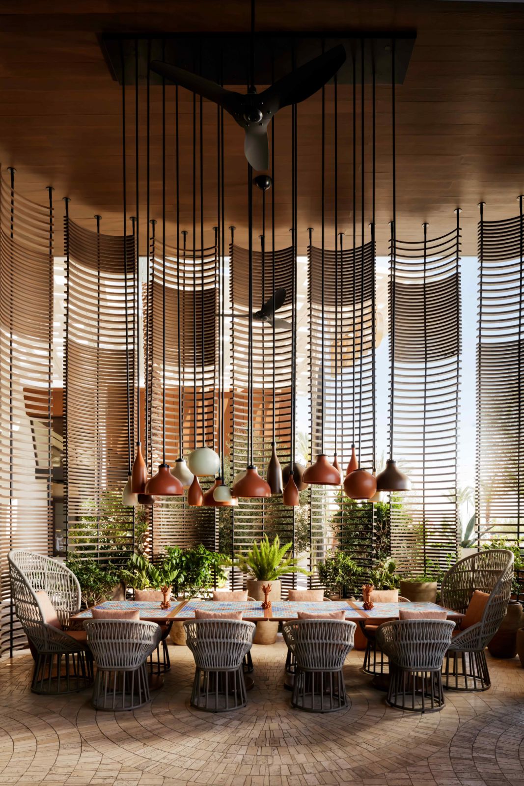 The outdoor patio with curved wood-slatted screens and 11-foot rope chandeliers