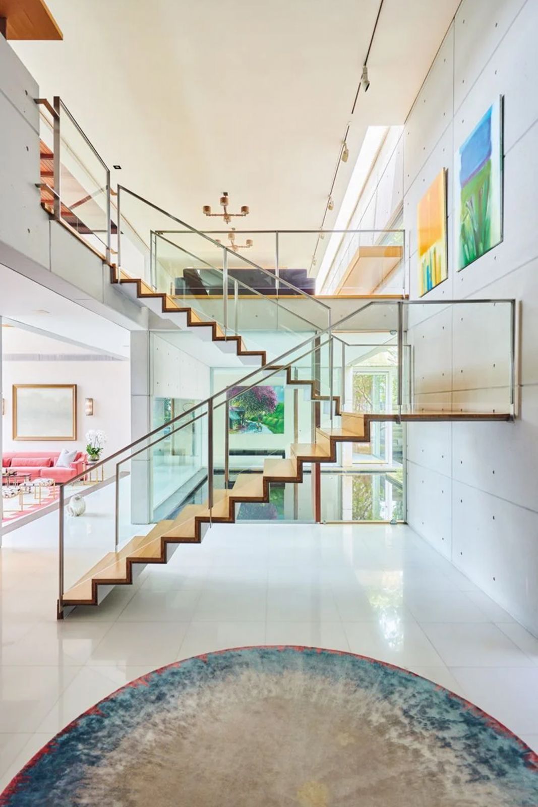 Glass balustrades allow onlookers to appreciate the architecture, furniture and paintings beyond the staircase
