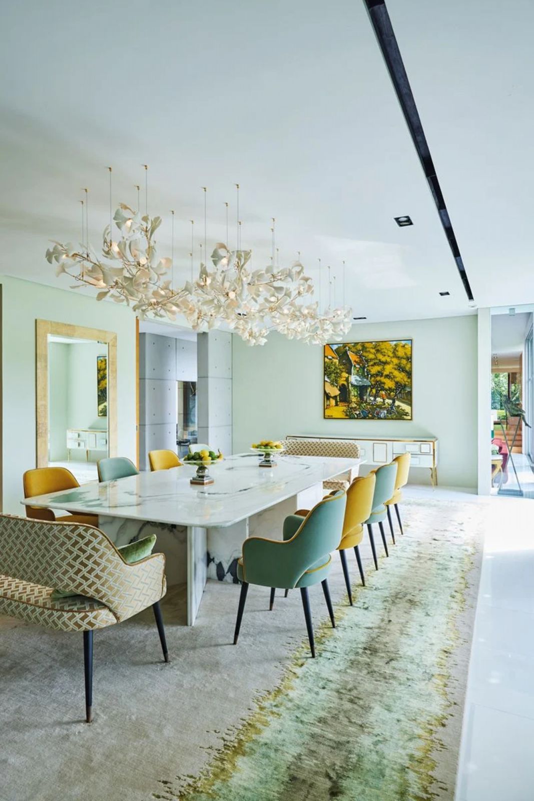 A Riviere rug and lighting installation by ceramic artist Andreea Braescu turn the dining room into a stunning extension of the landscape depicted in the painting hung at the head of the table
