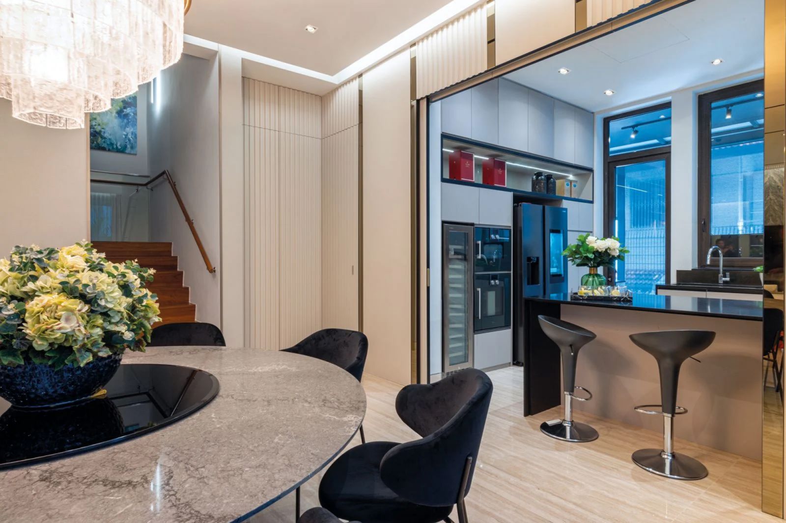 The dry kitchen can be hidden away behind telescopic fluted-glass doors or left open for guests to mingle around the island