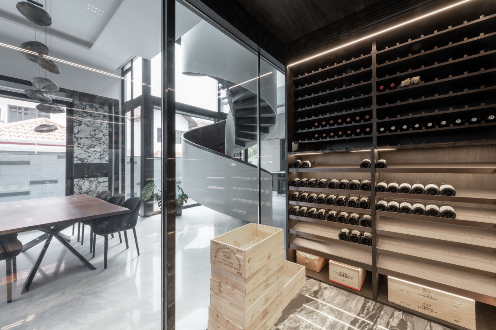 To create a framework for this glass-walled centrepiece, the designers used a palette of dark timber veneers throughout the living-dining area, plus wall finishes that resemble a natural rock formation