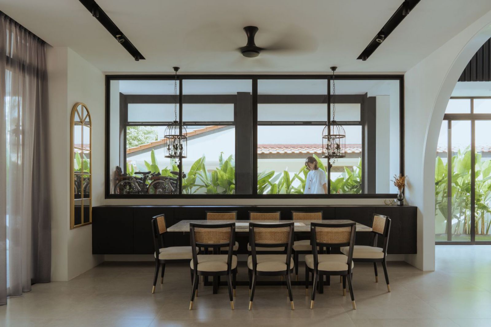 A tropical-style dining space overlooks the verdant garden
