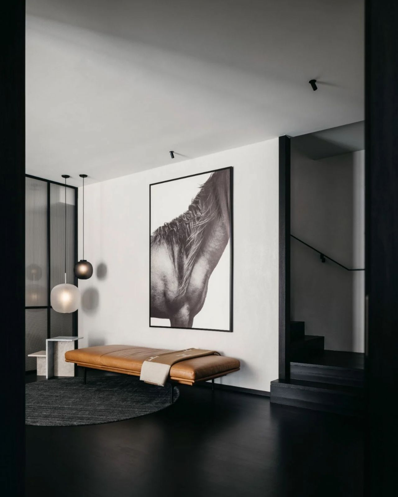 In the second-floor hallway is a Muuto Outline daybed from Grafunkt and an equestrian-themed art piece from P5 Studio
