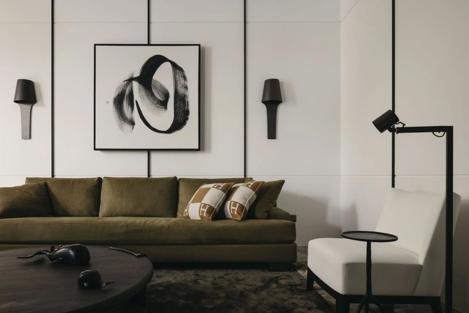 The olive-green Hunier sofa from Liaigre is paired with a work by local artist Simon Wee