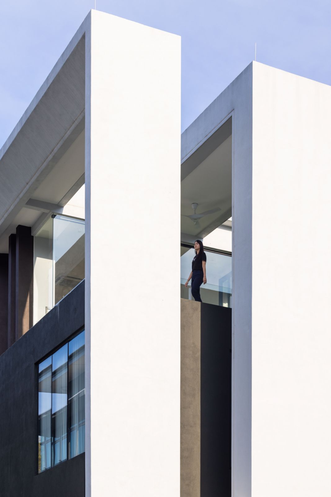 Dramatic vertical white columns and glass surfaces create a play of light and shadow