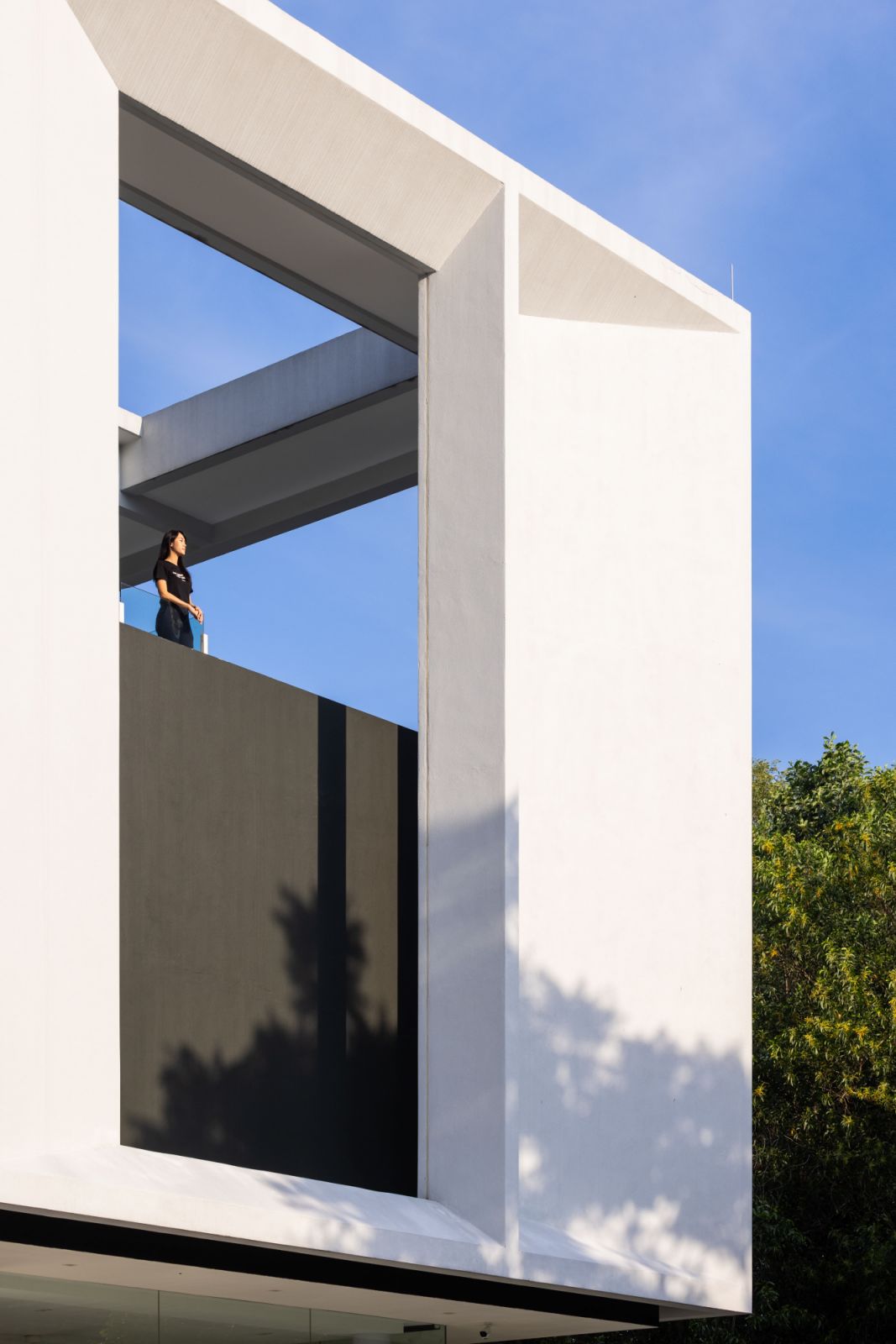 The bold architectural gesture of a floating white frame against the Malaysian sky exemplifies the home's design principle of 'less is more,