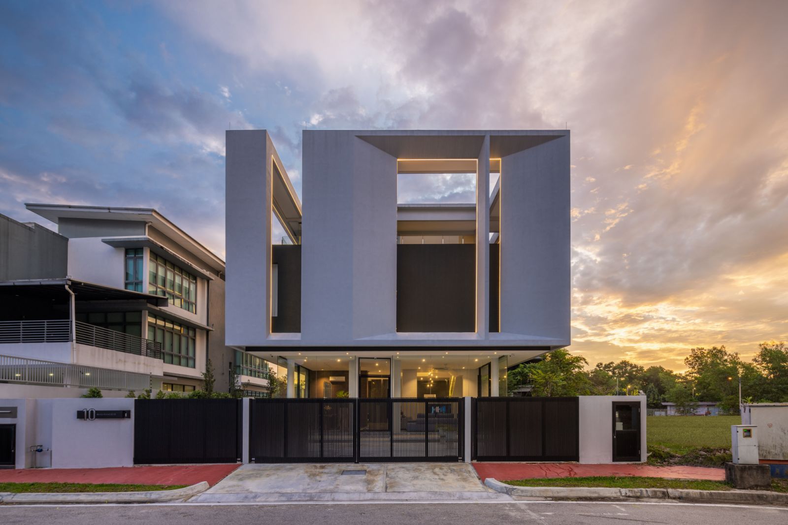The Float-Box House in Kota Damansara appears to levitate above its landscaped grounds, with its transparent ground floor creating an illusion of weightlessness