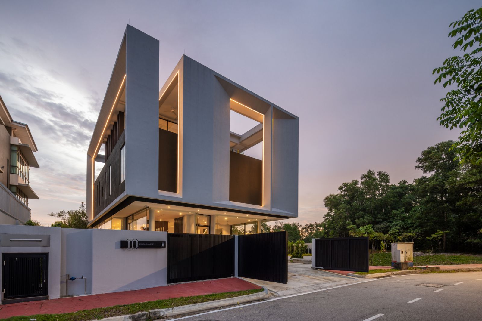The Float-Box House in Kota Damansara appears to levitate above its landscaped grounds, with its transparent ground floor creating an illusion of weightlessness