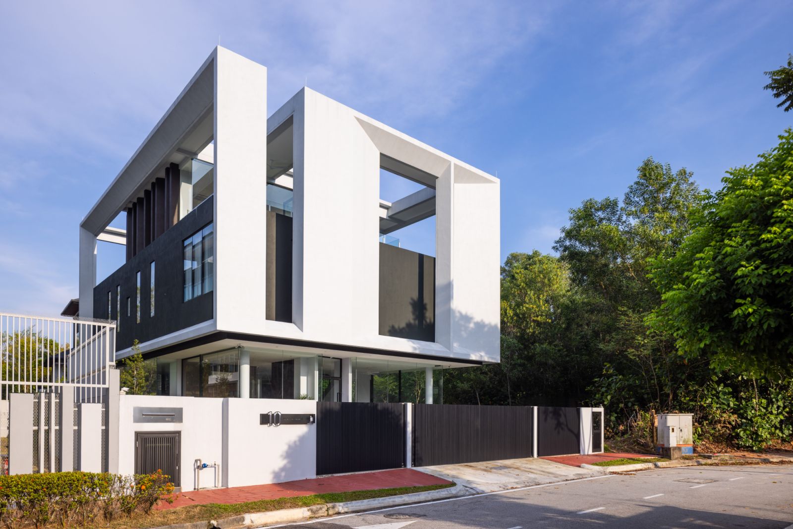 The Float-Box House in Kota Damansara appears to levitate above its landscaped grounds, with its transparent ground floor creating an illusion of weightlessness