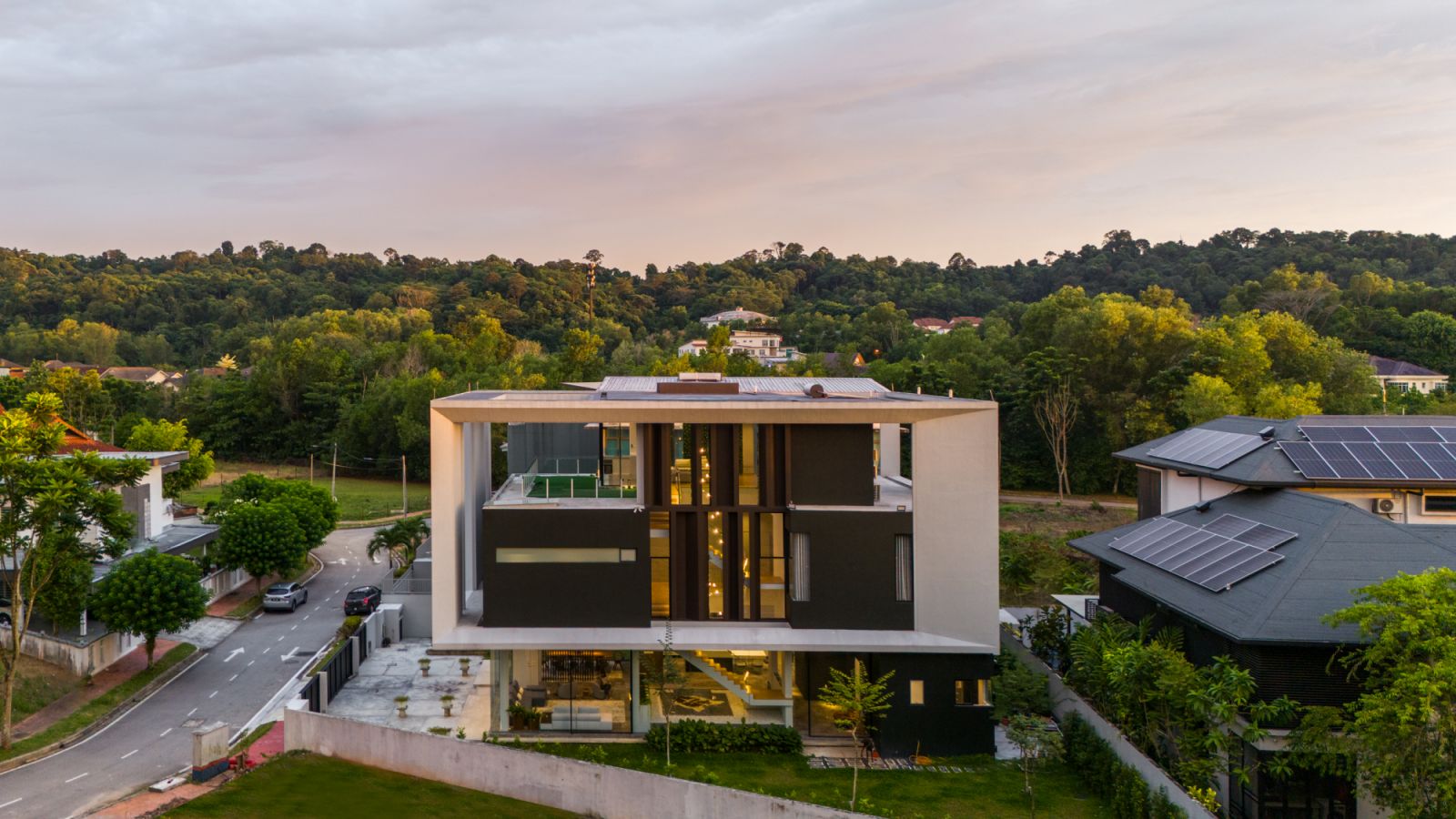 The Float-Box House in Kota Damansara appears to levitate above its landscaped grounds, with its transparent ground floor creating an illusion of weightlessness