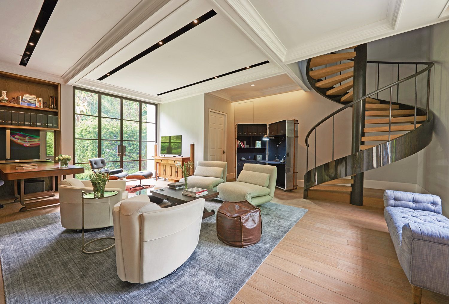 The study is a serene space filled with light, with a curved stairway that leads up to the guest room