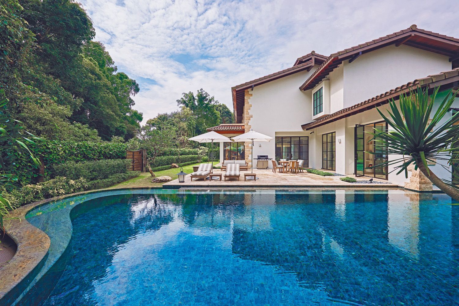 The silhouette of the saltwater swimming pool echoes the natural forms of the surrounding greenery, while its turquoise granite tiles are reminiscent of the Mediterranean Sea