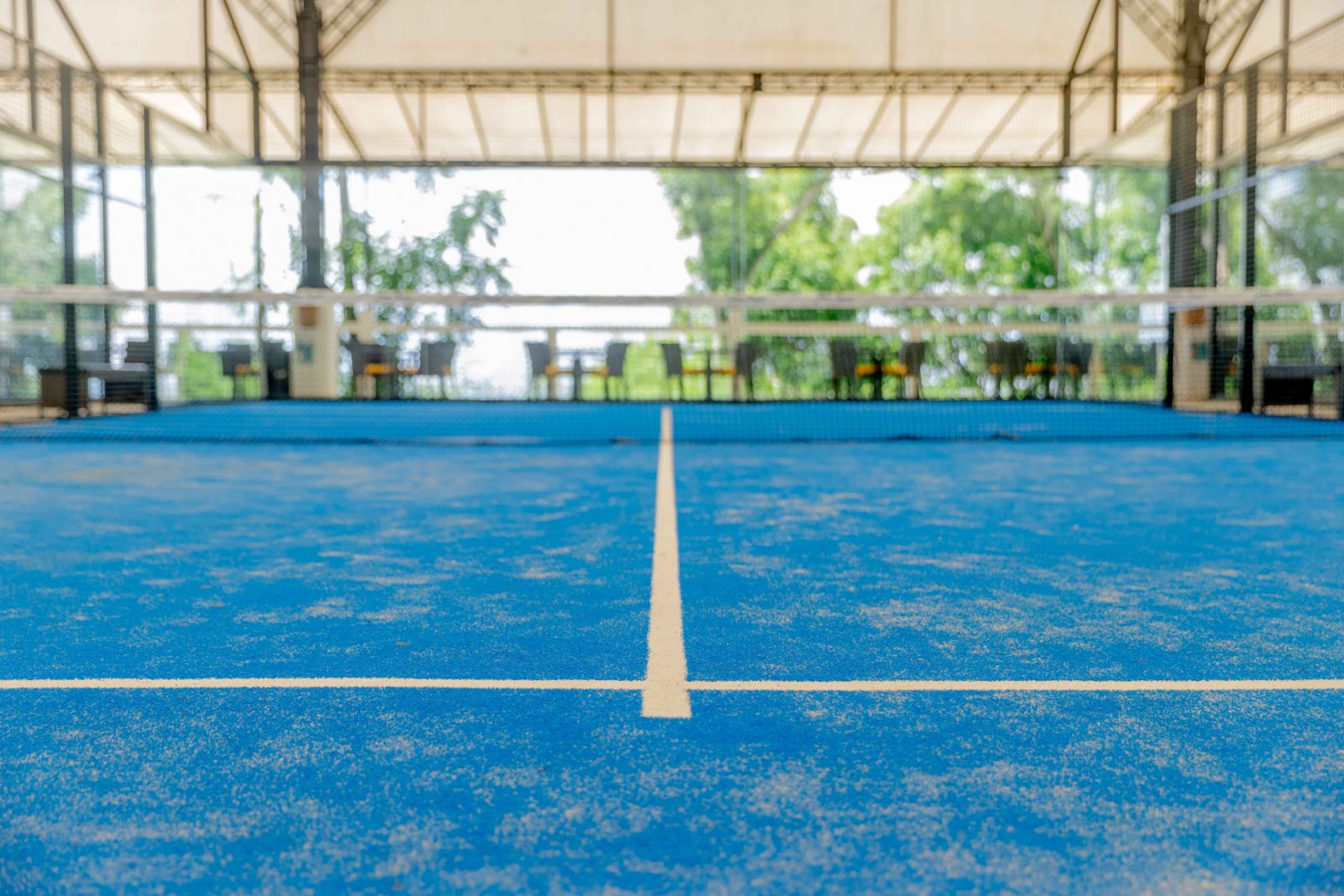 Padel courts feature lines that demarcate the court areas, but unlike tennis, players can use the full space, including the walls, for play (Photo: Steph Naval)