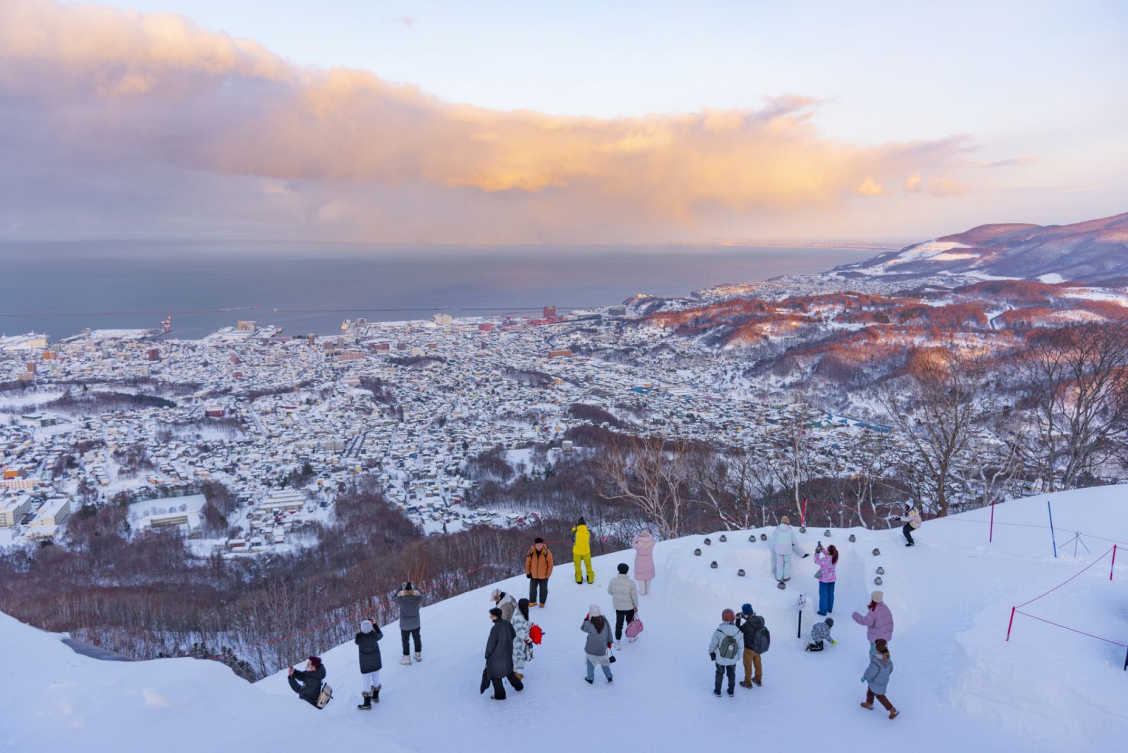 Japan - February 9, 2024 : Tourists enjoy sightseeing scenic view of Otaru city from Mt. Tenguyama Ropeway Observation Deck in winter, Otaru, Hokkaido, Japan