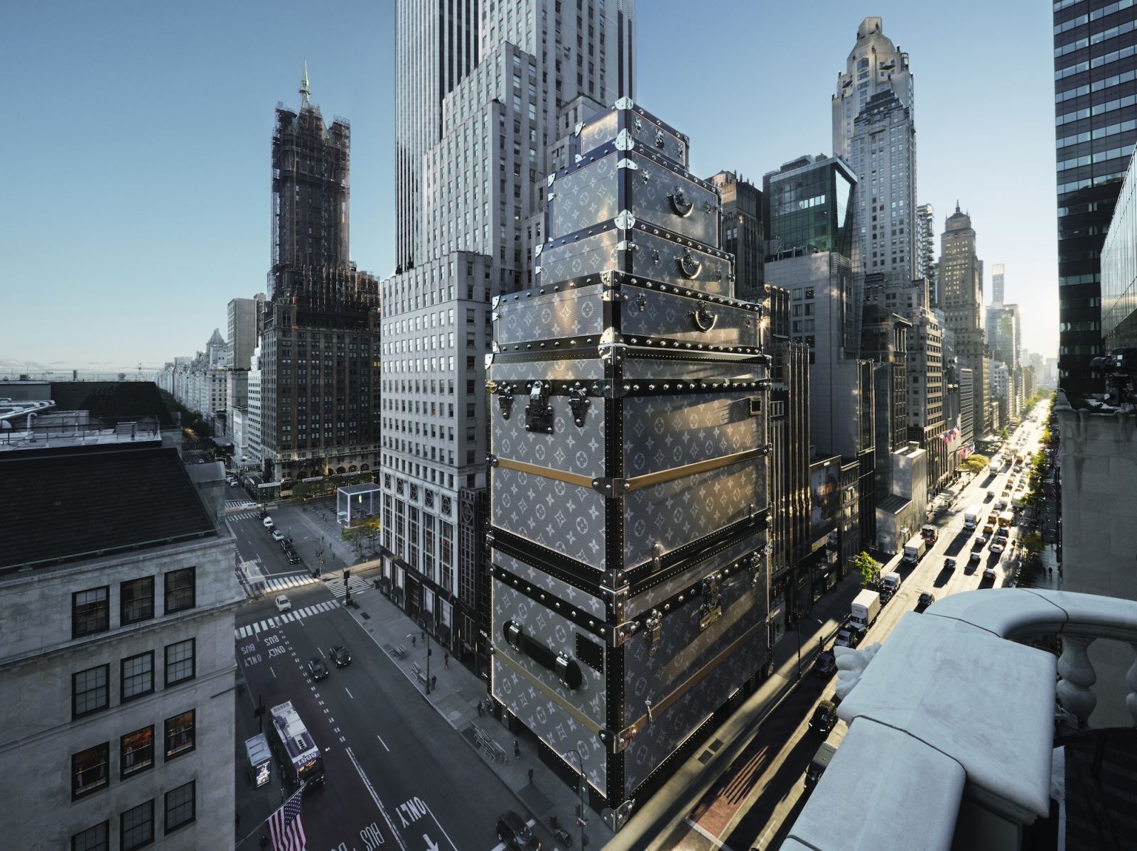 The exterior of Louis Vuitton’s flagship Fifth Avenue store undergoing renovation covered in  wrapped in a monumental metallic Monogram canvas trunk design that echoes the brand’s heritage