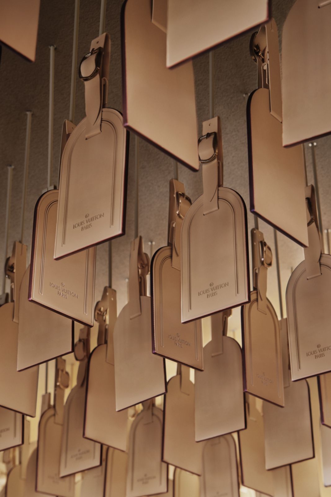 Detail of Louis Vuitton’s signature luggage tags in metallic finish, arranged in a rhythmic pattern as part of the store’s decorative elements