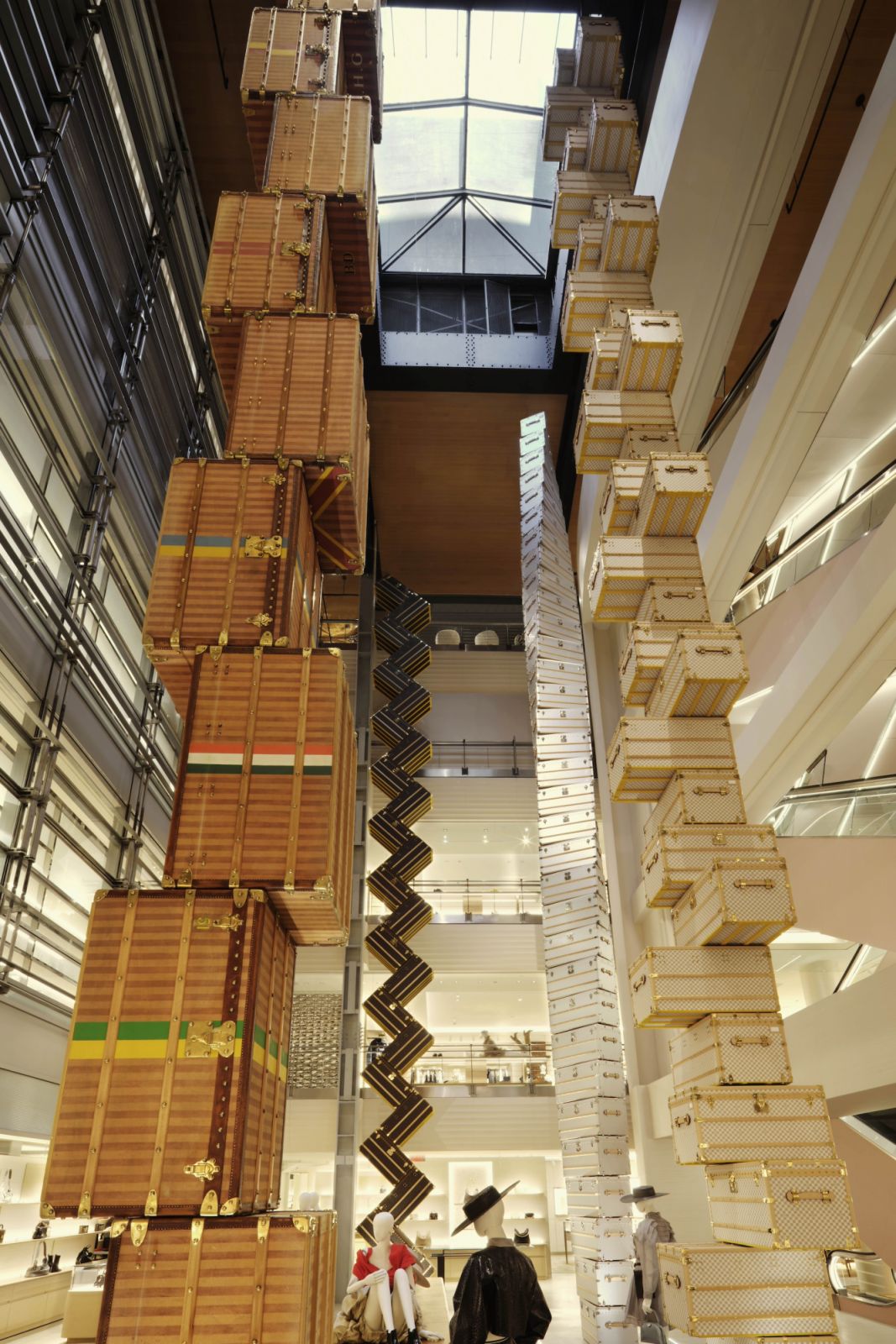 OMA’s dramatic sculptural installation in the store’s atrium, featuring four 16-meter towers composed of stacked Courrier Lozine 90 trunks