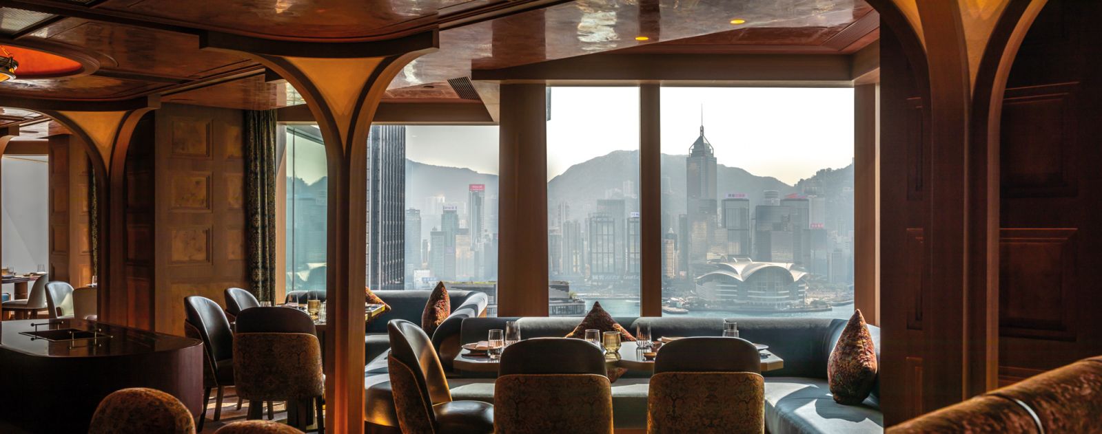 In the restaurant’s dining area, arched columns frame diners and the vista of Hong Kong’s skyline