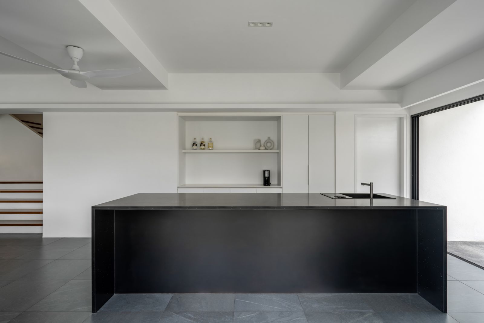 White built-in cabinetry provides seamless storage while maintaining the clean aesthetic