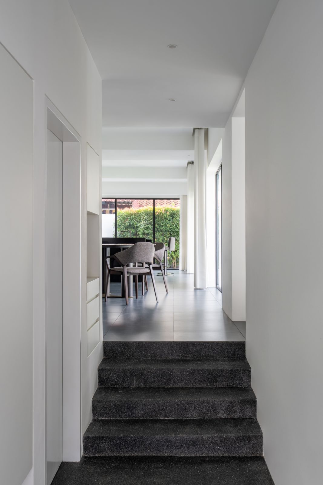 Dark floors ground the pure white spaces