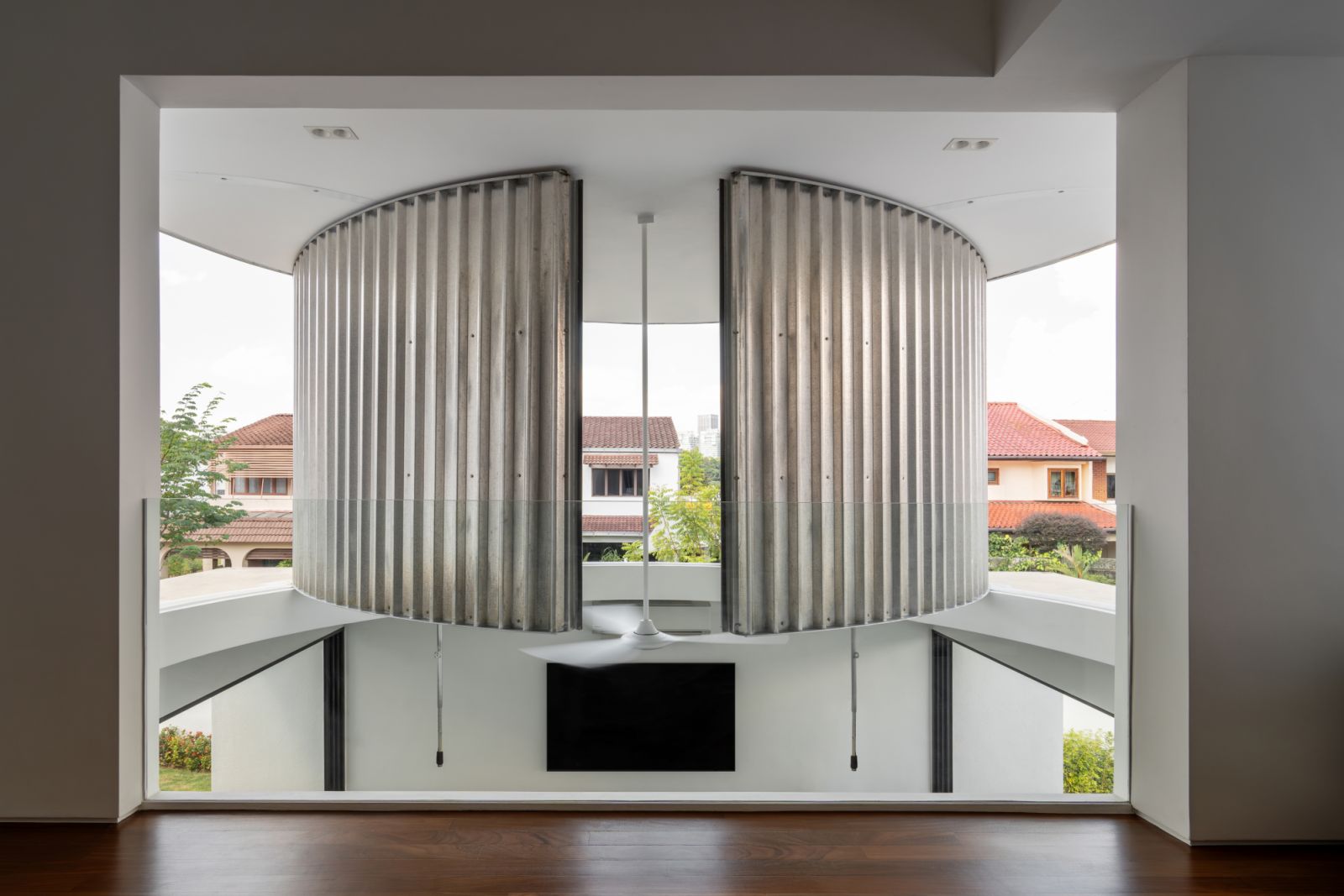 The distinctive ‘moon doors’–two quarter-circle panels of corrugated metal that can pivot to control light and ventilation–frame the outdoor view