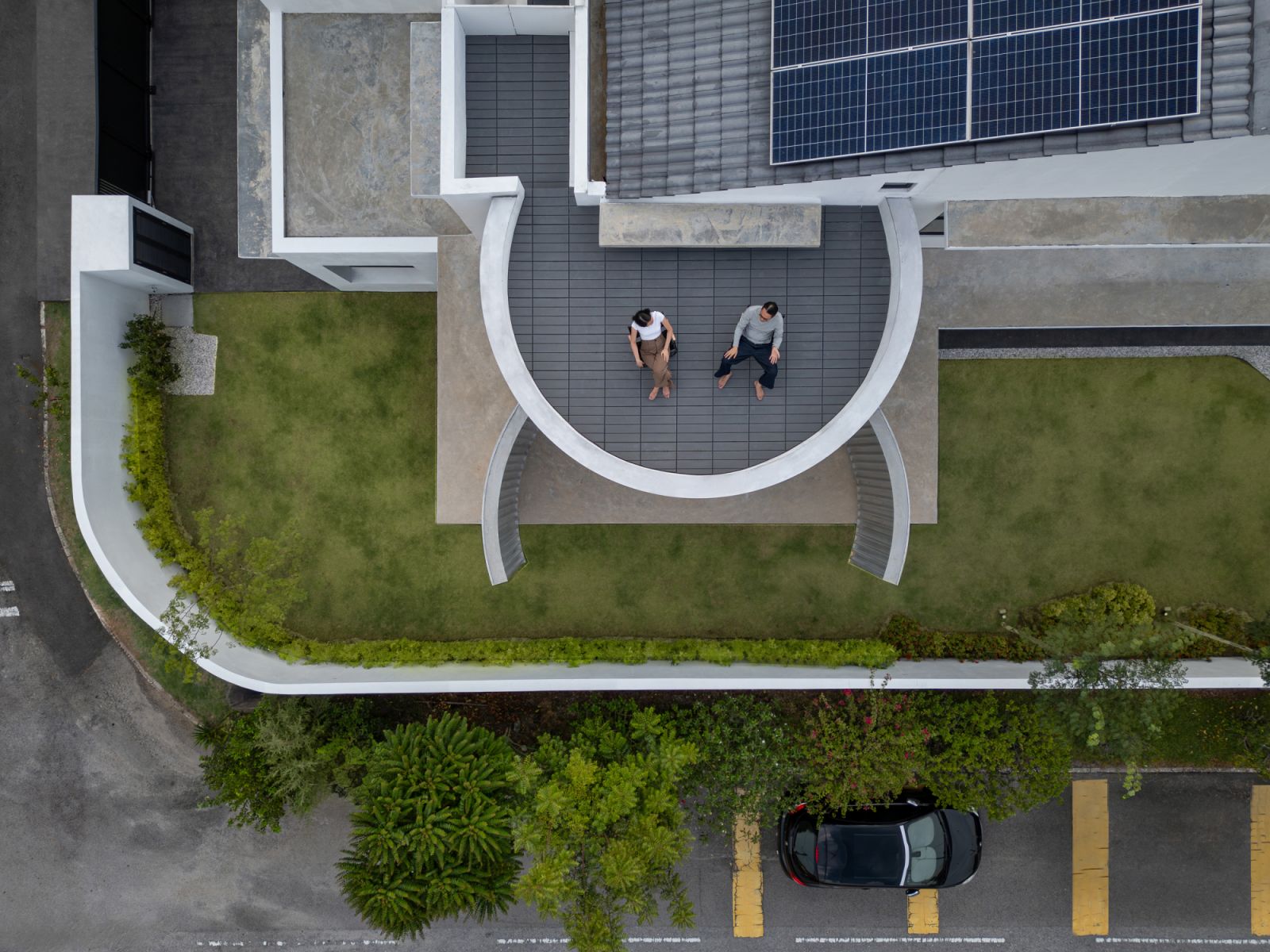 An aerial view of the CC House reveals its distinctive crescent-shaped design and architectural composition