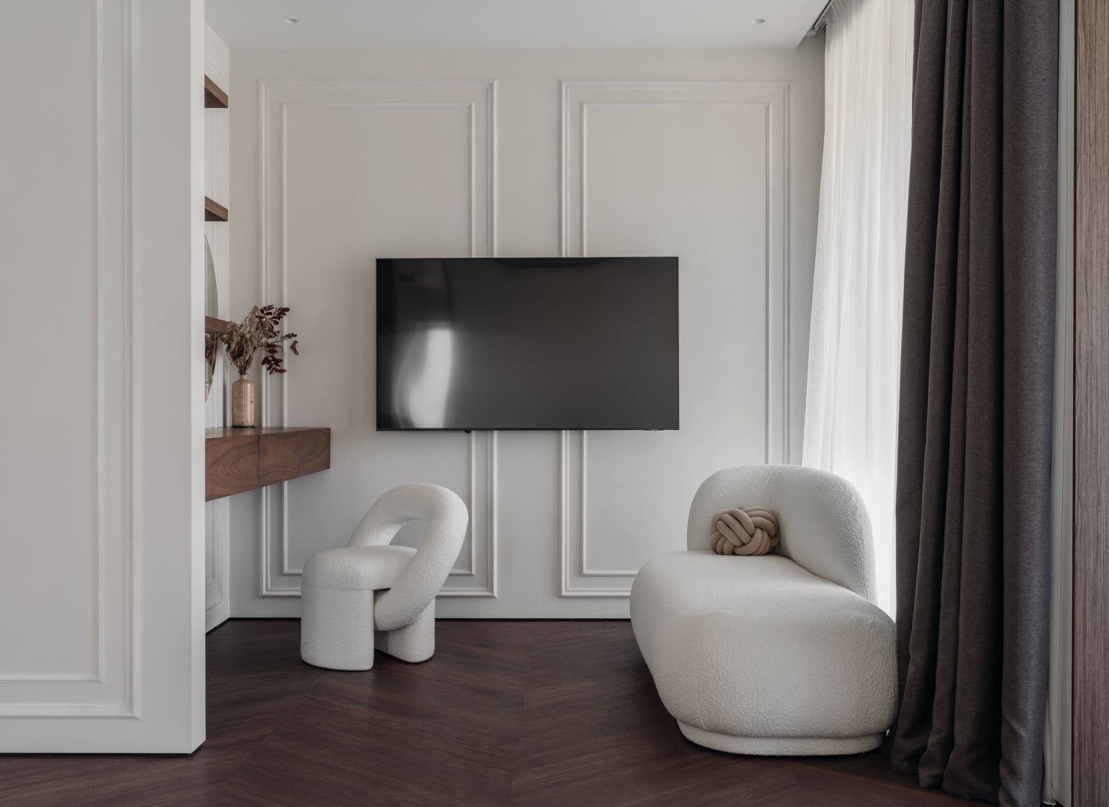 A cosy entertainment corner in the master bedroom sports curvy furniture