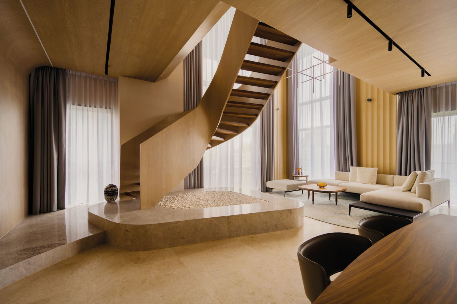 The sculptural “oculus” staircase is the focal point of the living hall in this Orchard home