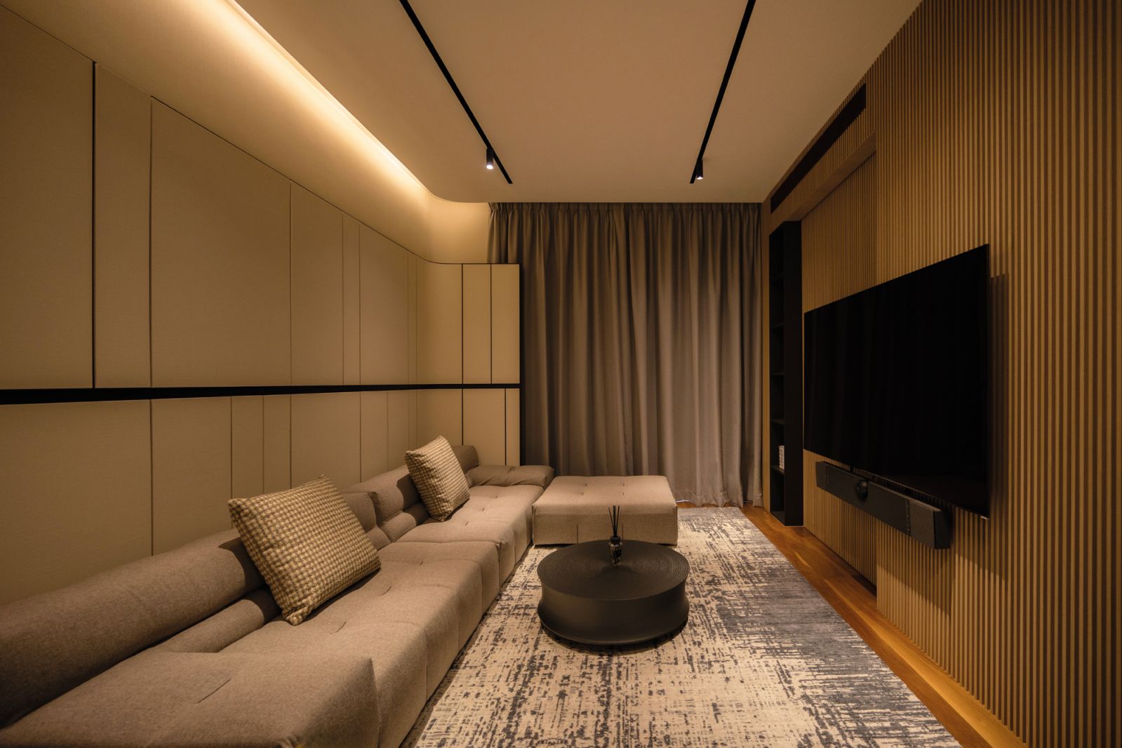 The entertainment room upstairs, finished with a large, patterned rug and acoustic panels