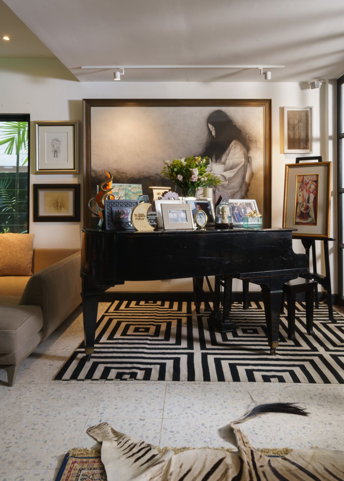 Paintings and photographs surround the grand piano