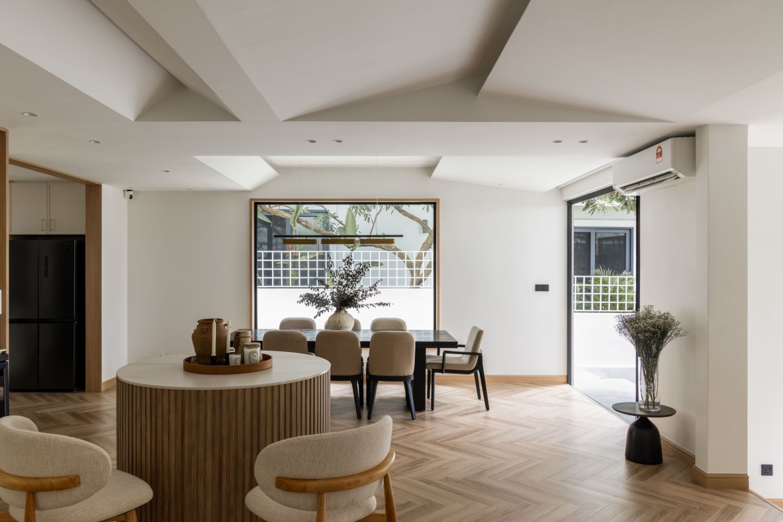 The strategic removal of walls transformed the original compartmentalized layout into a fluid sequence of interconnected spaces, united by consistent materials and bathed in natural light