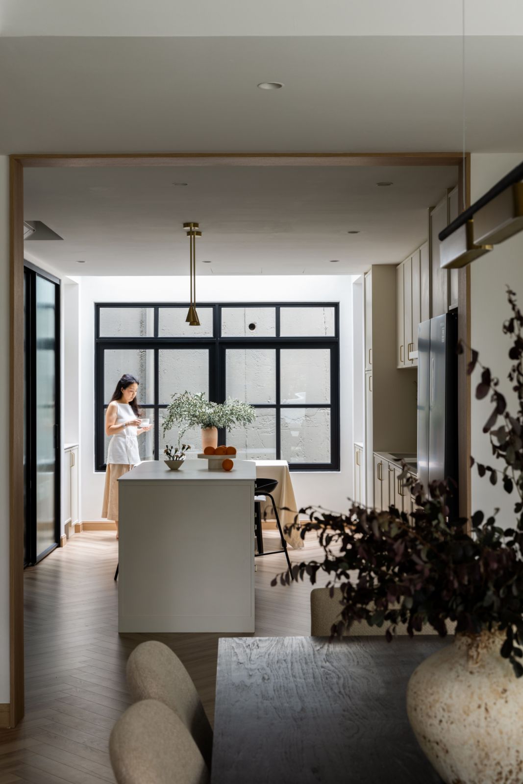 Indoor plants soften the monochromatic palette while reinforcing the home's connection to nature, a key theme throughout the renovation