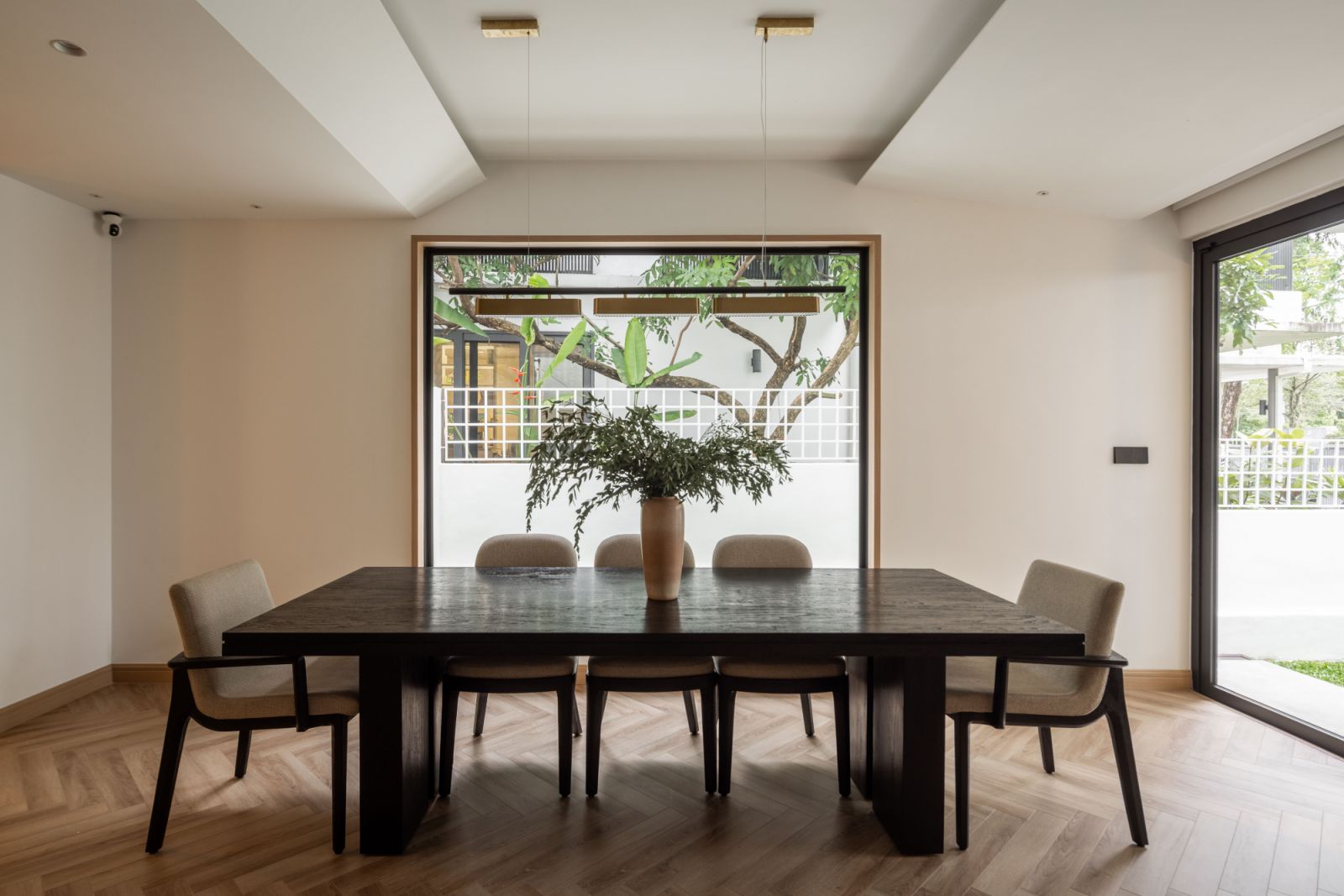 The dining area is anchored by a dramatic black dining table, with Urbanesta pendant lighting above, demonstrating the studio's commitment to combining functionality with modern aesthetics