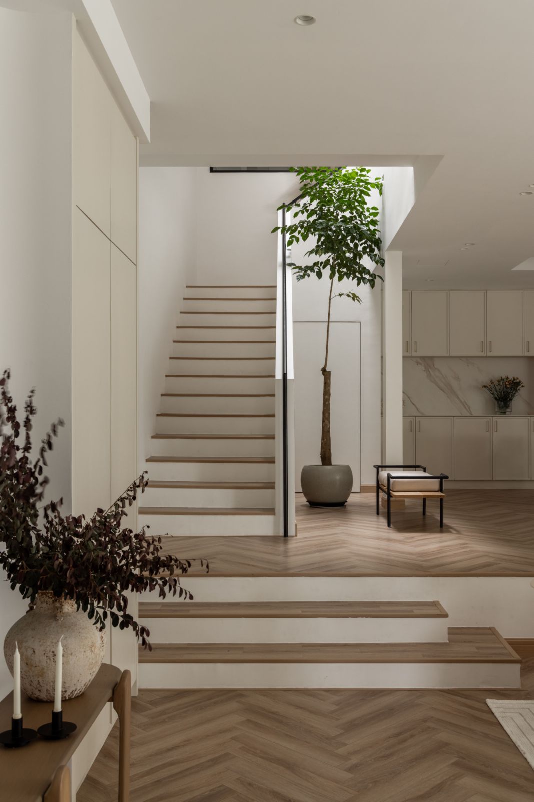Natural light streams through expansive windows, while carefully selected materials create a warm, inviting atmosphere