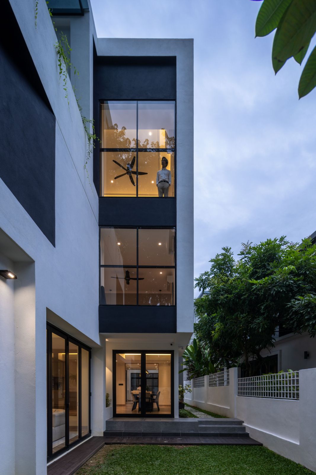A defining feature of this renovation is the dramatic use of floor-to-ceiling windows across all three levels, creating a seamless dialogue between interior and exterior spaces