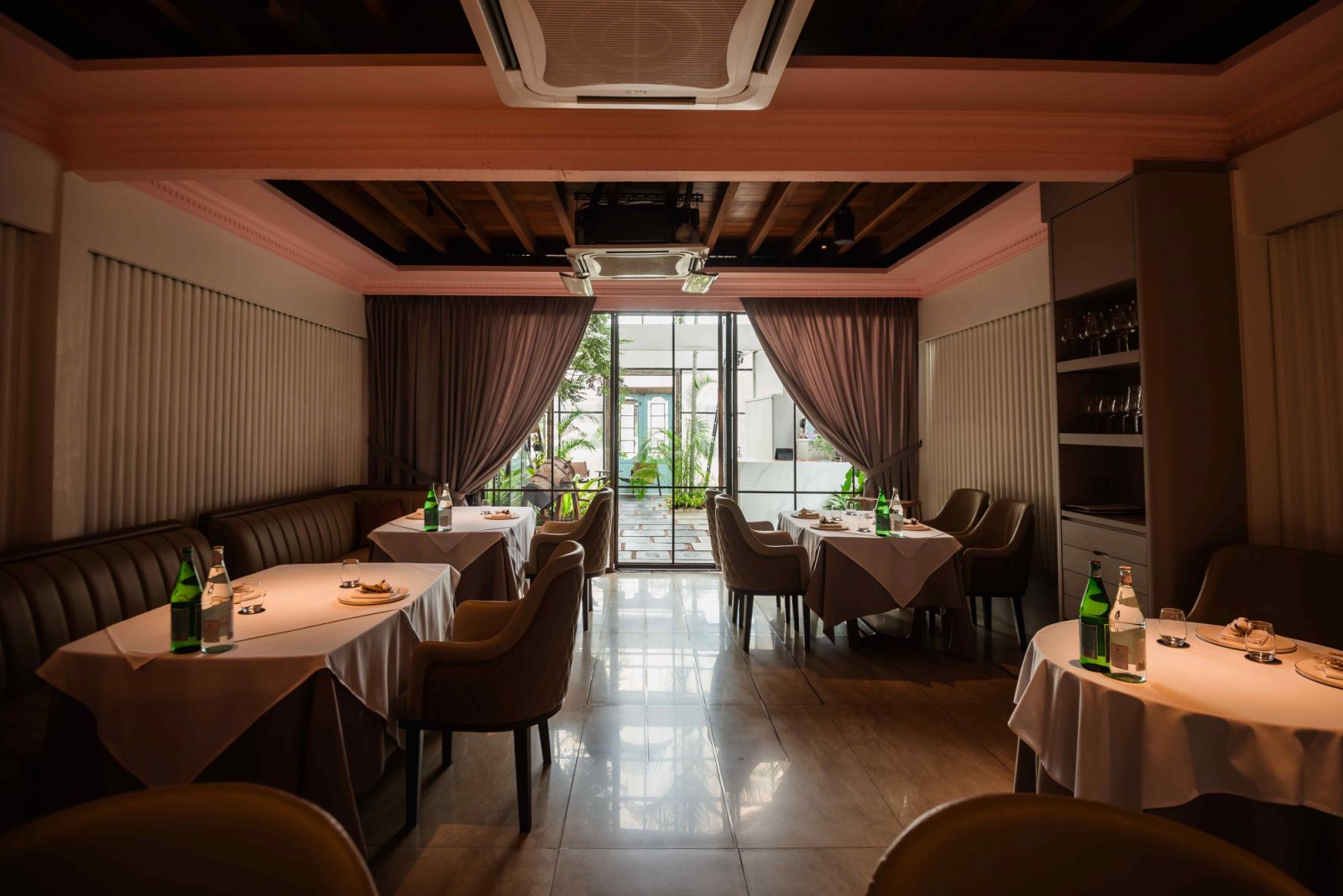 Warm wooden tables and consoles soften the industrial backdrop