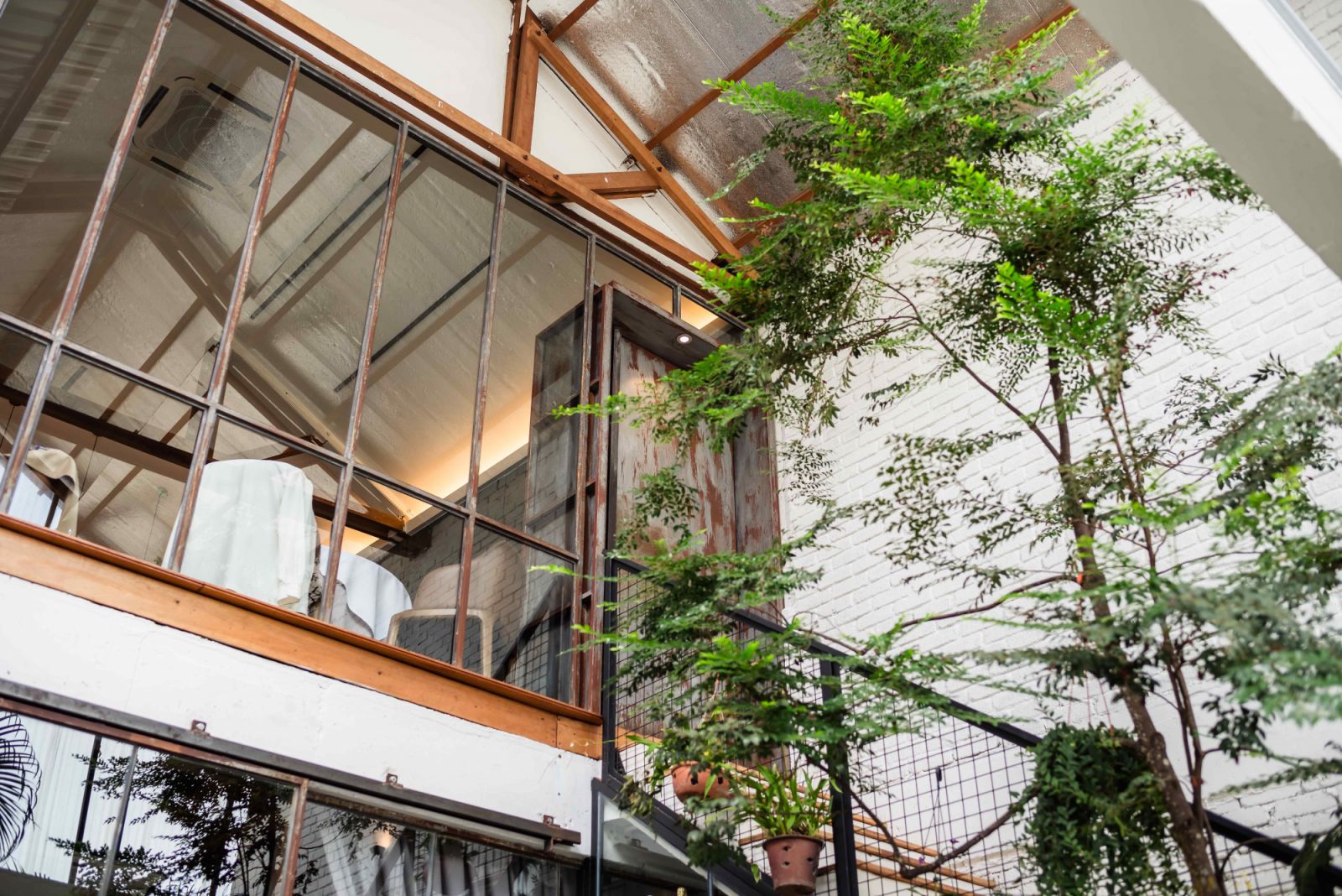 Unfinished walls, exposed wooden beams, and stone cement flooring celebrates the building’s industrial heritage