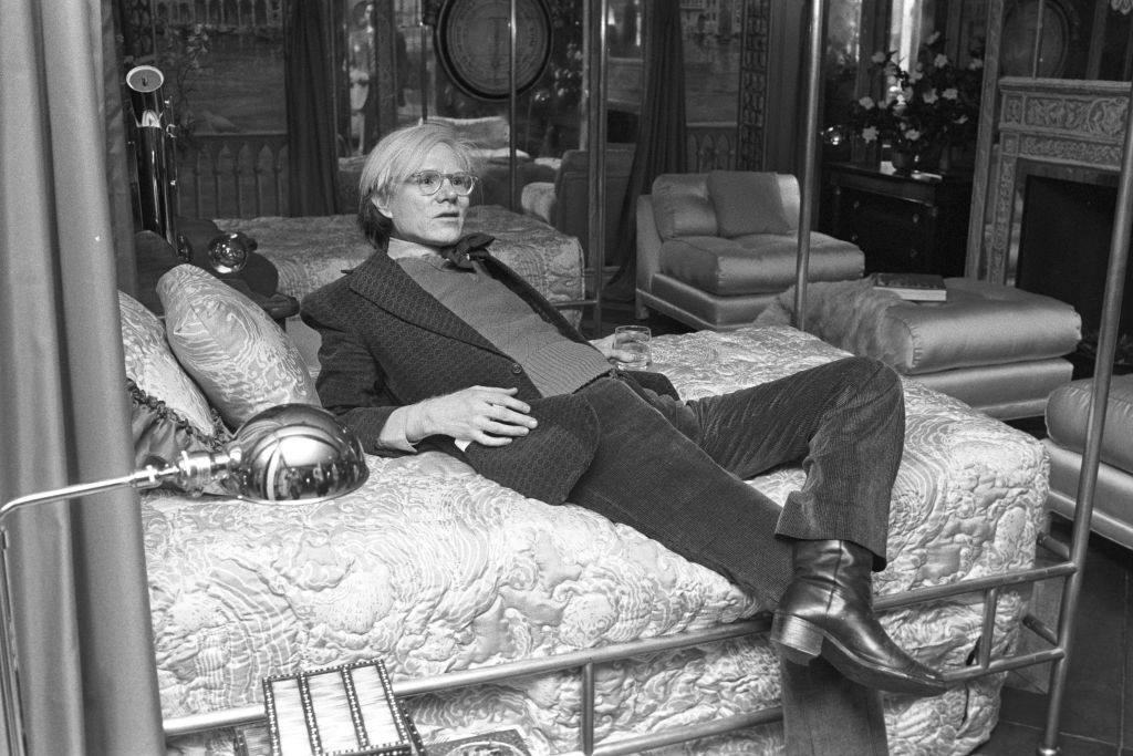Published; Cropped for publication; Artist Andy Warhol lounges with a drink in the Venice, Queen of the Adriatic room at the Italian themed 'La Belle Campagna' opening for the spring designer model rooms inspired by elegant vacation areas in Italy on the fifth floor of Bloomingdale's on April 10, 1973 in New York..Article title: 'Eye View: Rooms at the Top (Photo by Fairchild Archive/Penske Media via Getty Images)
