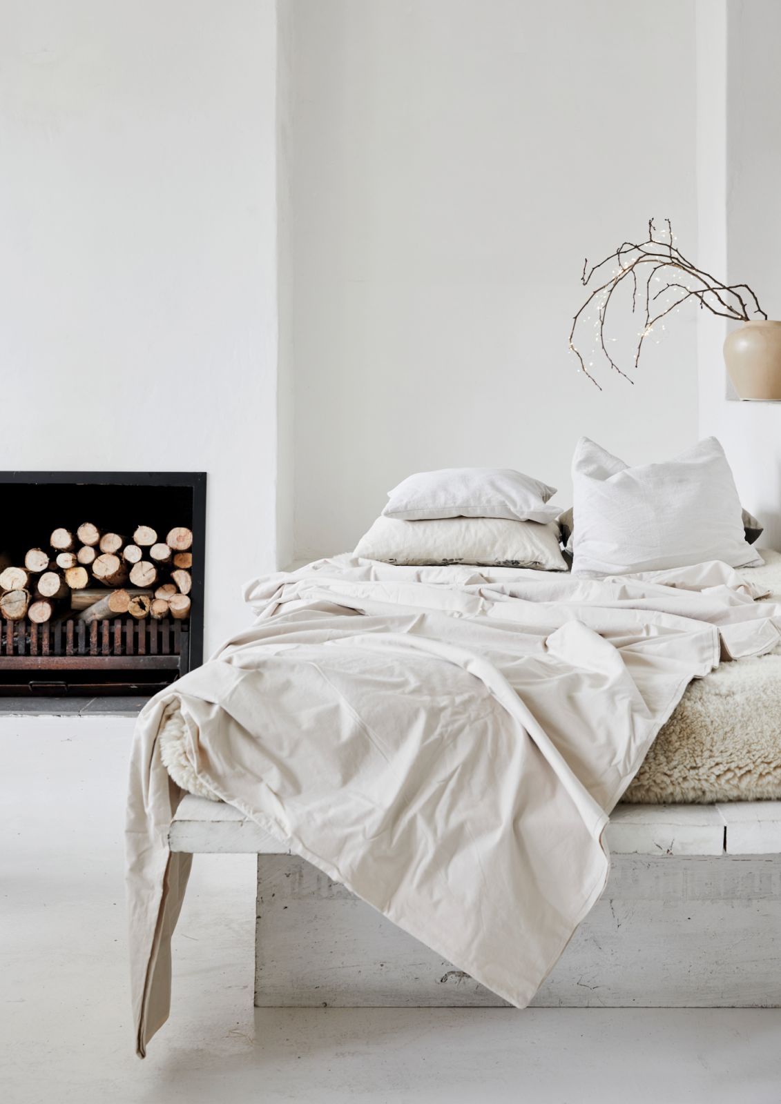 The bedroom’s cream-on-cream look is perfectly offset by freshly cut logs