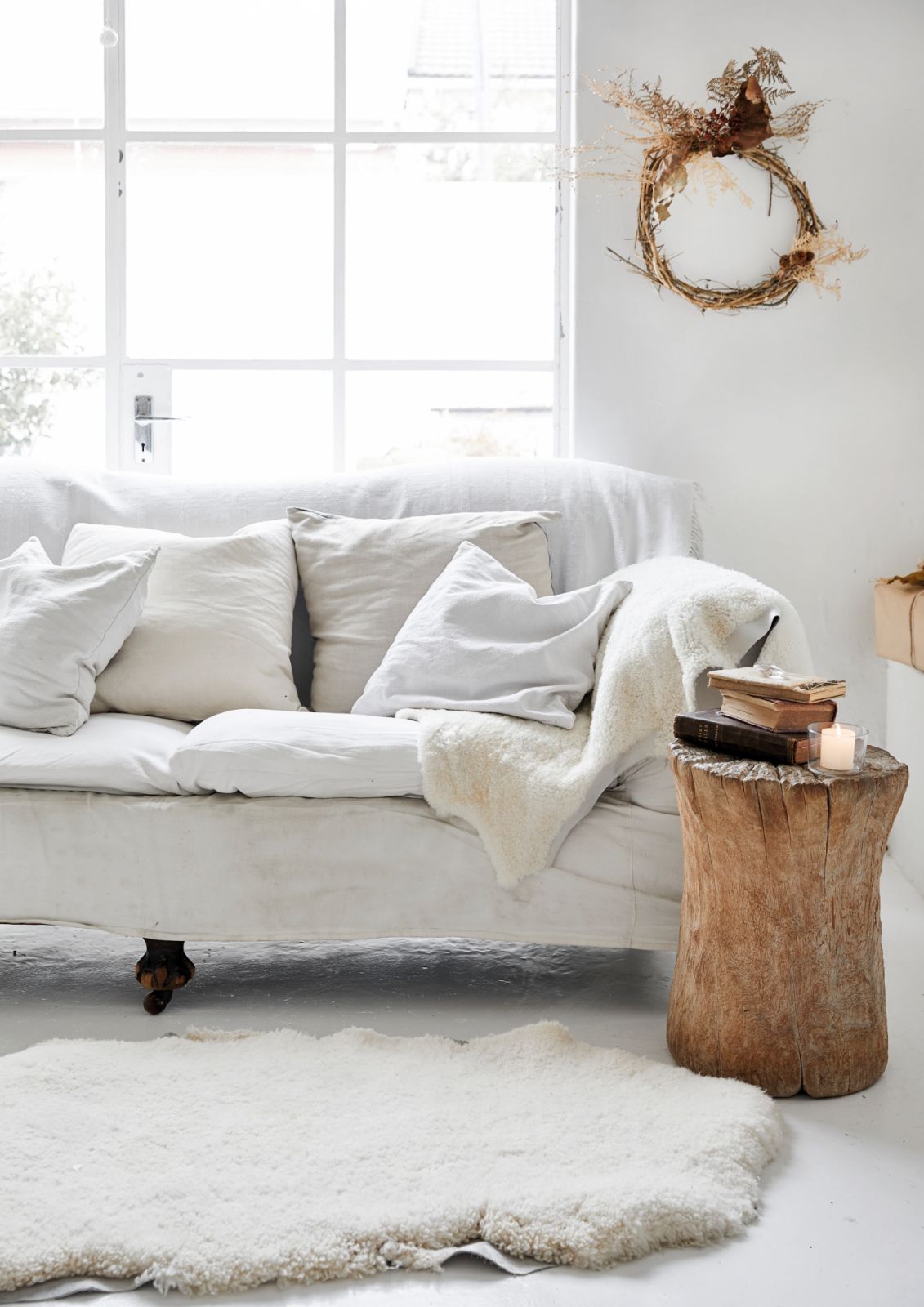 A white vintage sofa draped with sheepskins