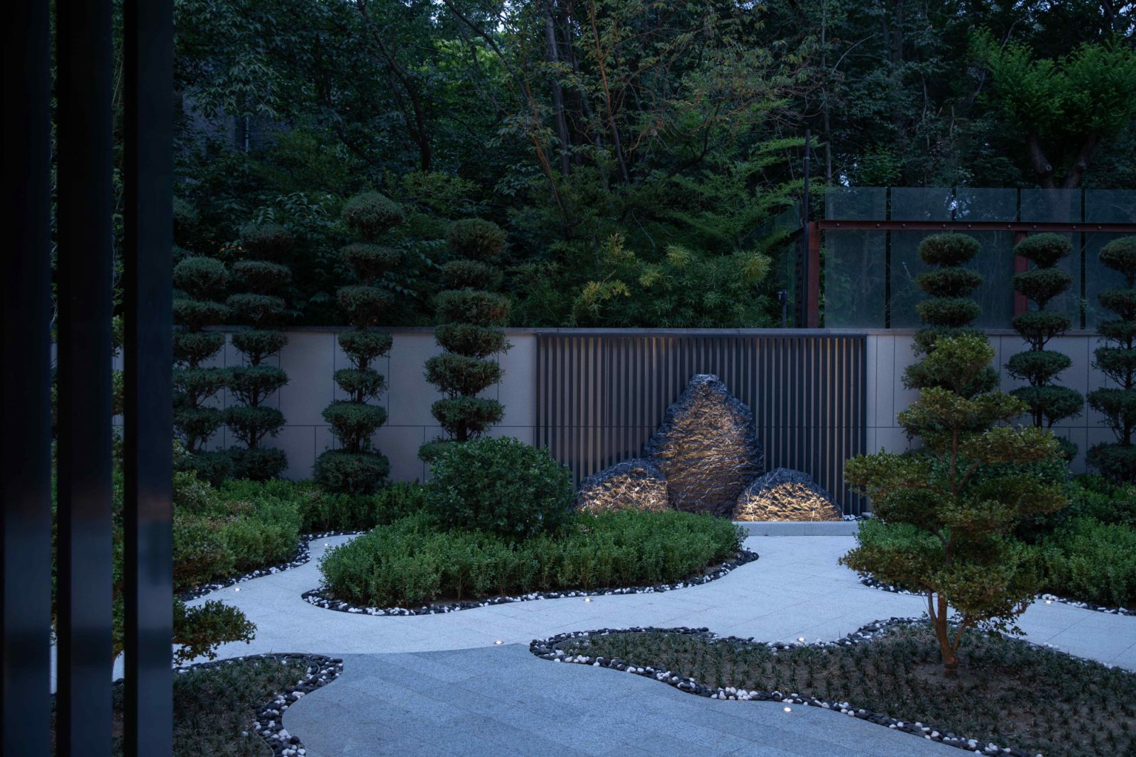 The manicured front garden with verdant pockets and winding pathways