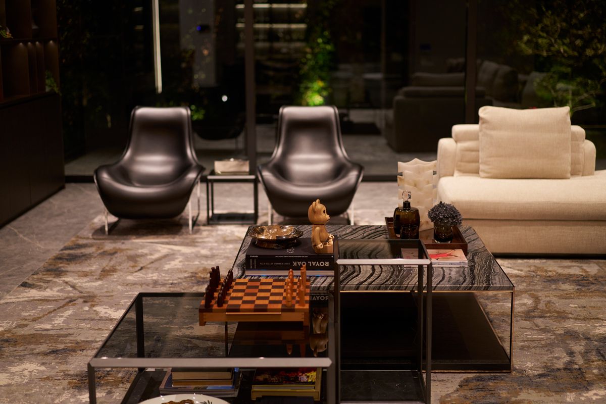 A collection of low tables with a curated selection of tomes and accessories, including a chess set, reflects the occupants’ personalities